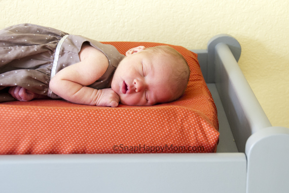 newborn sleeping on table