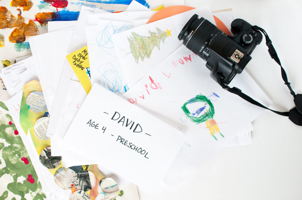 pile of kid art with dslr camera to document it